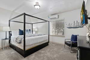 Bedroom with carpet floors and a wall mounted AC