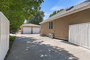 View of home's exterior with stucco siding, an outbuilding, a garage, and a shingled roof
