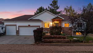 Ranch-style house featuring concrete driveway, an attached garage, and stone siding