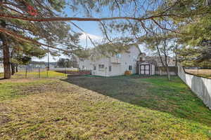 Back of property with a fenced backyard and a storage shed