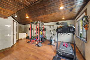Exercise room with wood finished floors and wood ceiling and sink
