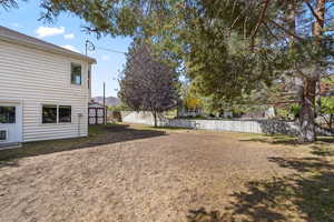 Fenced backyard featuring a storage unit