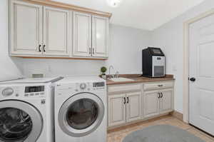 Laundry room featuring cabinet space, separate washer and dryer, and light tile  floors Full access to Garage