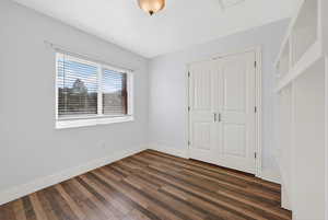 Unfurnished bedroom with dark wood-type flooring and a closet