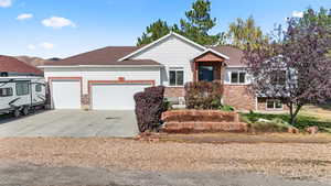 Ranch-style house featuring stone siding, concrete driveway, and an attached garage