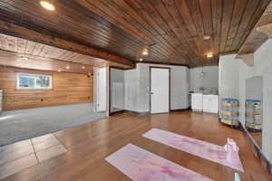 Below grade area with wooden ceiling, wood walls, wood-type flooring, carpet floors, and recessed lighting