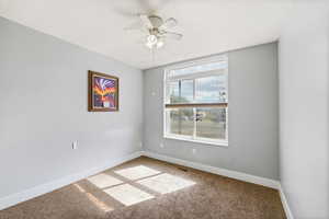 Carpeted bedroom featuring baseboards and ceiling fan