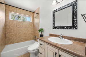 Full bath with washtub / shower combination, vanity, and light tile  floors