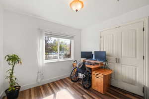 Home office featuring baseboards and dark wood-style flooring