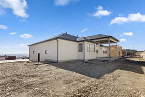 Rear view of house with a patio and stucco siding