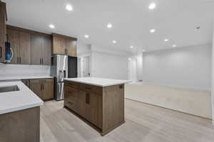 Kitchen with recessed lighting, appliances with stainless steel finishes, light wood-type flooring, a center island, and modern cabinets