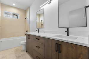 Bathroom with double vanity, shower / bathtub combination, and recessed lighting