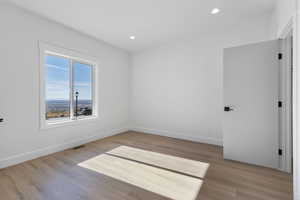 Empty room with recessed lighting and light wood-style flooring