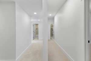Hallway featuring light colored carpet and recessed lighting