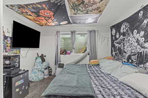 Bedroom featuring carpet floors and stainless steel fridge