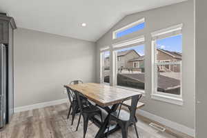 Dining space featuring lofted ceiling, recessed lighting, light wood-type flooring, and a residential view