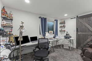 Office area featuring a barn door, carpet, and recessed lighting