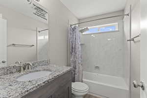 Bathroom featuring shower / bath combo with shower curtain and vanity