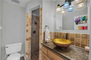 Bathroom featuring vanity, tasteful backsplash, and a walk in shower