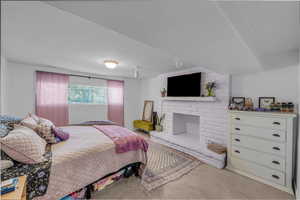 Carpeted bedroom featuring a fireplace