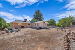 Rear view of house featuring an outdoor fire pit and a patio