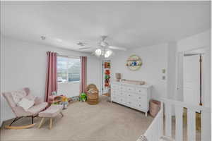 Bedroom featuring light carpet and a ceiling fan