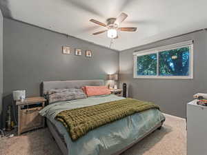 Primary bedroom with carpet flooring and a ceiling fan