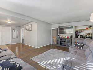 Living room featuring dark wood-style floors and baseboards