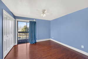 Unfurnished room featuring dark wood-style floors, baseboard heating, a textured ceiling, and a ceiling fan