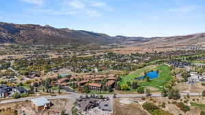 Aerial overview of property's location featuring a water and mountain view, nearby suburban area, and a golf course