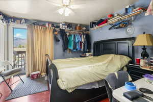 Bedroom featuring a deck, a textured ceiling, wood finished floors, and ceiling fan