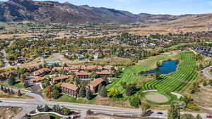 Aerial overview of property's location featuring a water and mountain view and a golf club