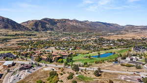 Aerial view of property and surrounding area with a water and mountain view