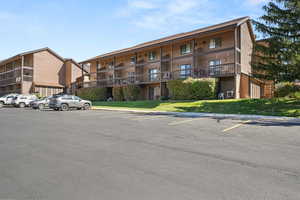 View of apartment building / complex with uncovered parking