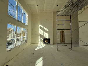 Unfurnished living room featuring a fireplace and a towering ceiling