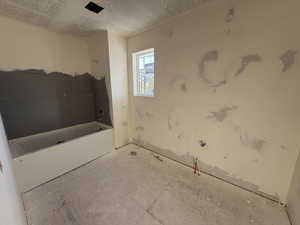 Bathroom featuring a tub and a textured ceiling