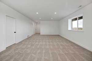 Spare room featuring recessed lighting and light colored carpet