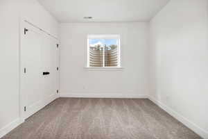 Unfurnished bedroom featuring light carpet and a closet