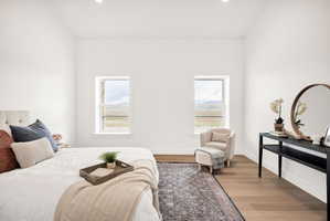 Bedroom with wood finished floors, recessed lighting, and multiple windows