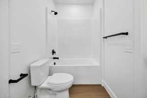 Full bath with bathing tub / shower combination and wood finished floors