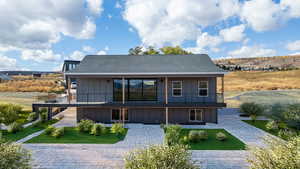 Back of house featuring a balcony, board and batten siding, and a lawn,landscape in this photo is virtual