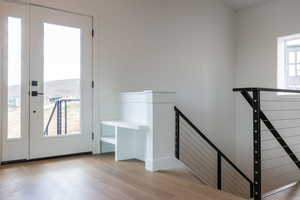 Stairway featuring wood finished floors, a water view, and french doors