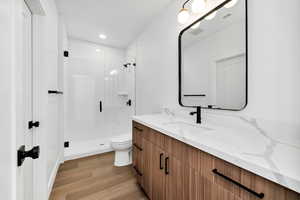 Bathroom with vanity, light wood-style floors, a stall shower, and recessed lighting