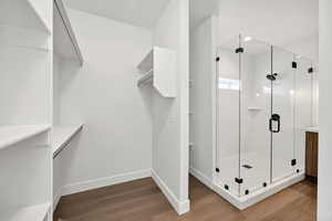 Bathroom featuring dark wood-style floors and a stall shower