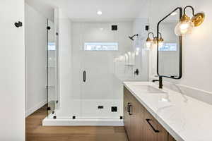 Full bathroom featuring vanity, dark wood-style flooring, a shower stall, and recessed lighting