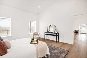 Bedroom featuring light wood-type flooring, vaulted ceiling, and recessed lighting