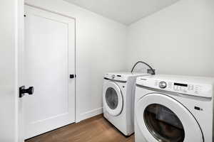 Laundry room with wood finished floors and separate washer and dryer