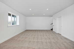 Spare room with light carpet, recessed lighting, and stairs
