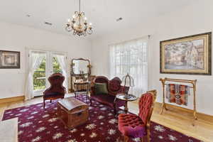 Living area featuring wood finished floors, a chandelier, and lofted ceiling