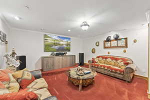 Carpeted living area with crown molding